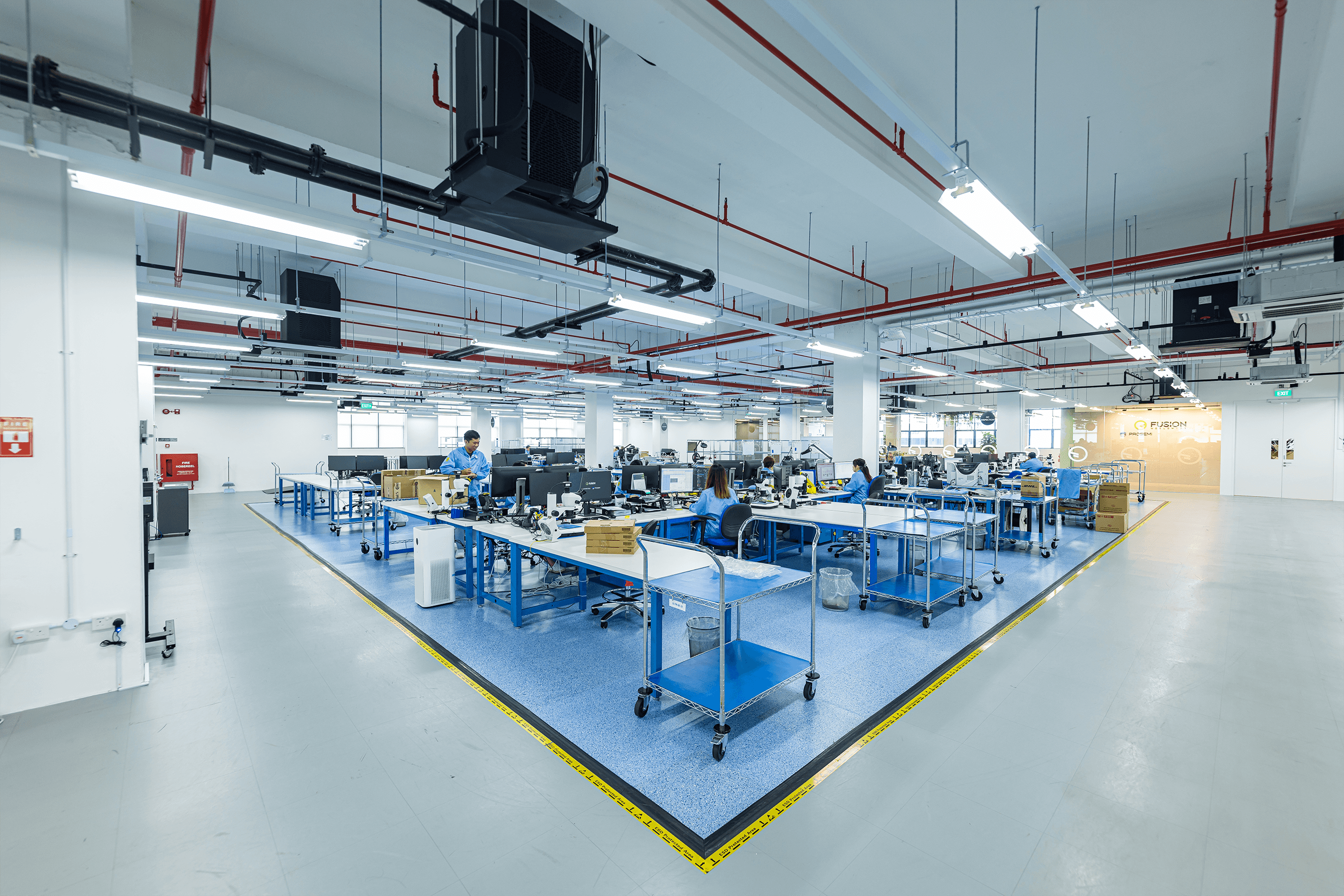 Quality control inspectors sitting at desks at the Prosemi testing facility in Singapore