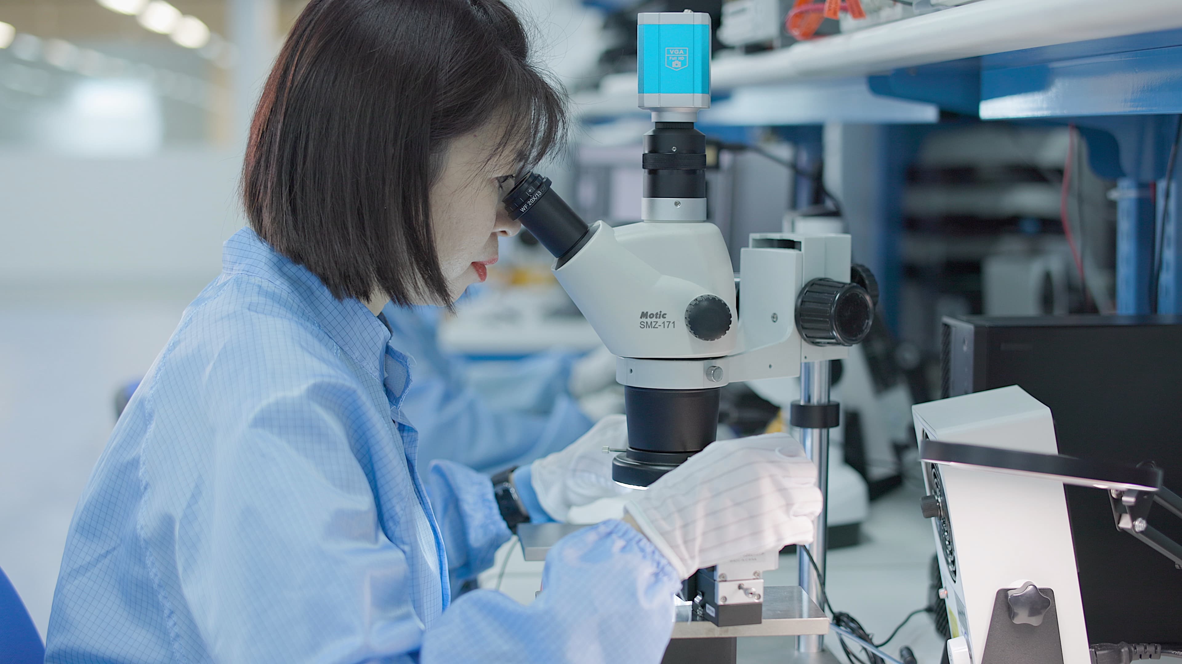 Fusion quality control inspector examining a sample under a microscope