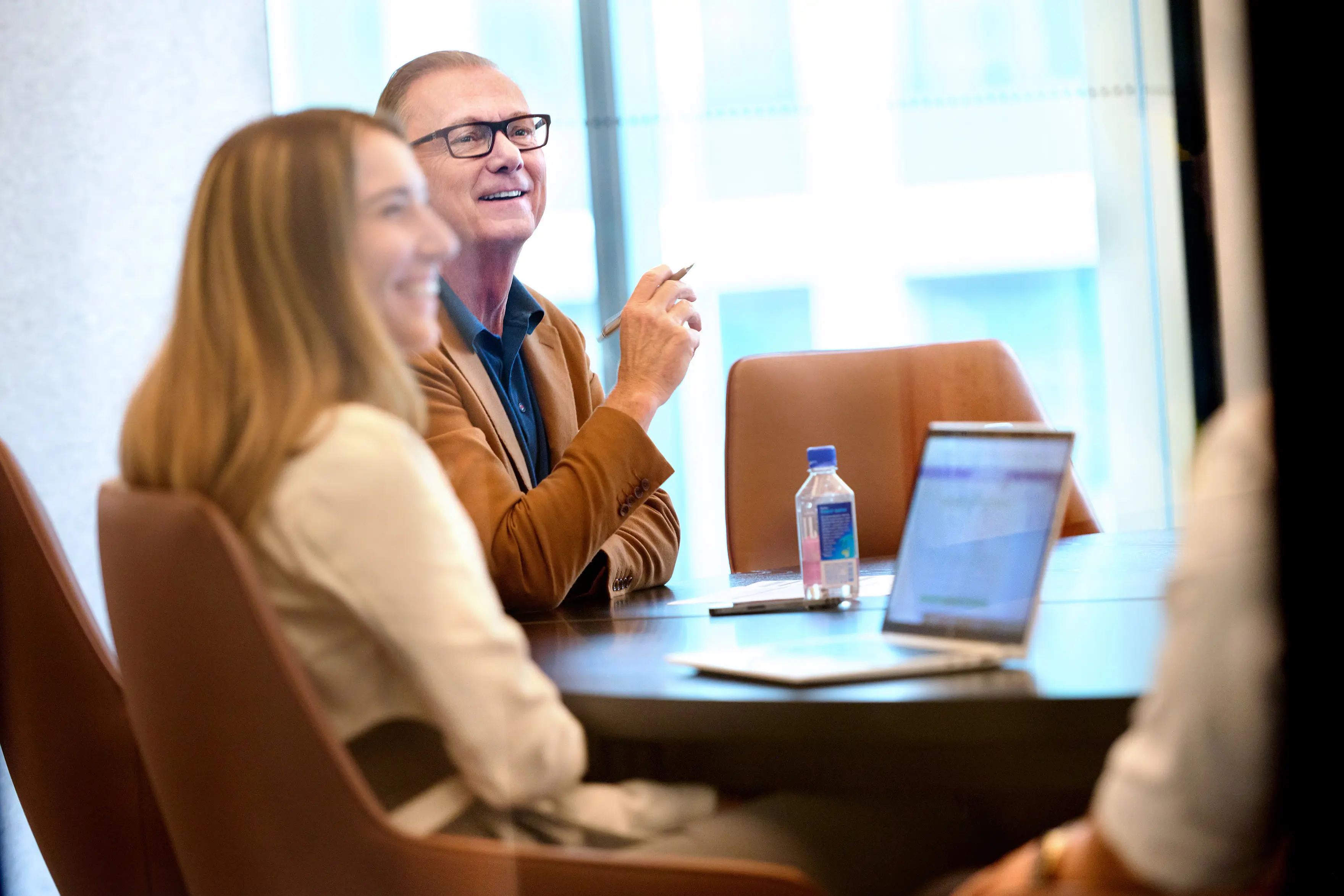 Fusion CEO laughing with employees in a conference room