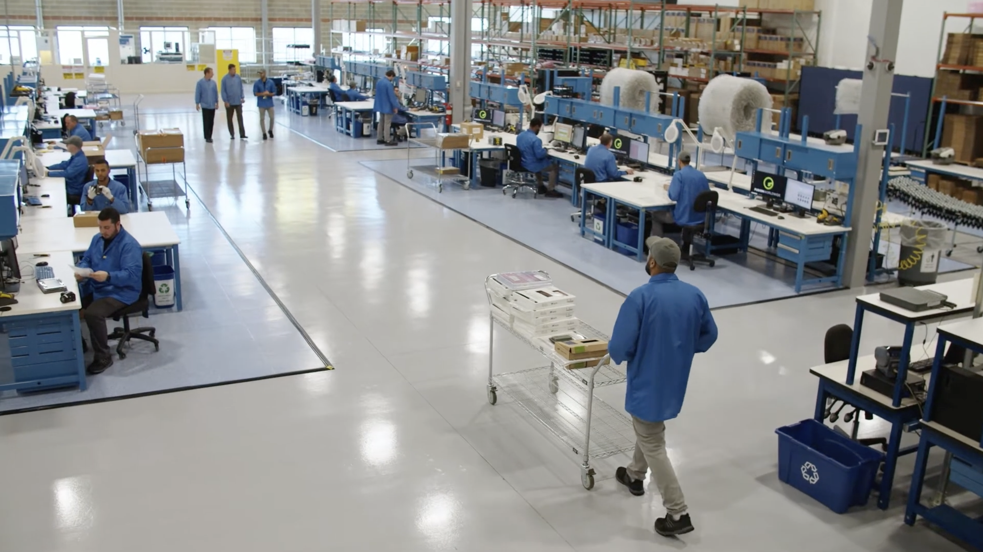 Fusion Worldwide's quality inspection team in a warehouse surrounded by desks and equipment